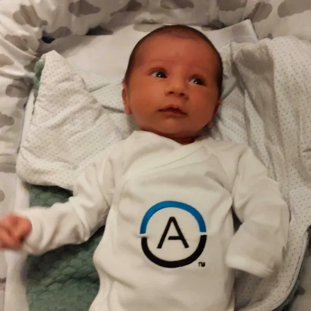 An infant wearing an Anonos onesie.