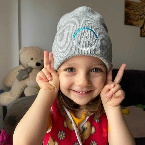 A young child wearing an Anonos beanie.